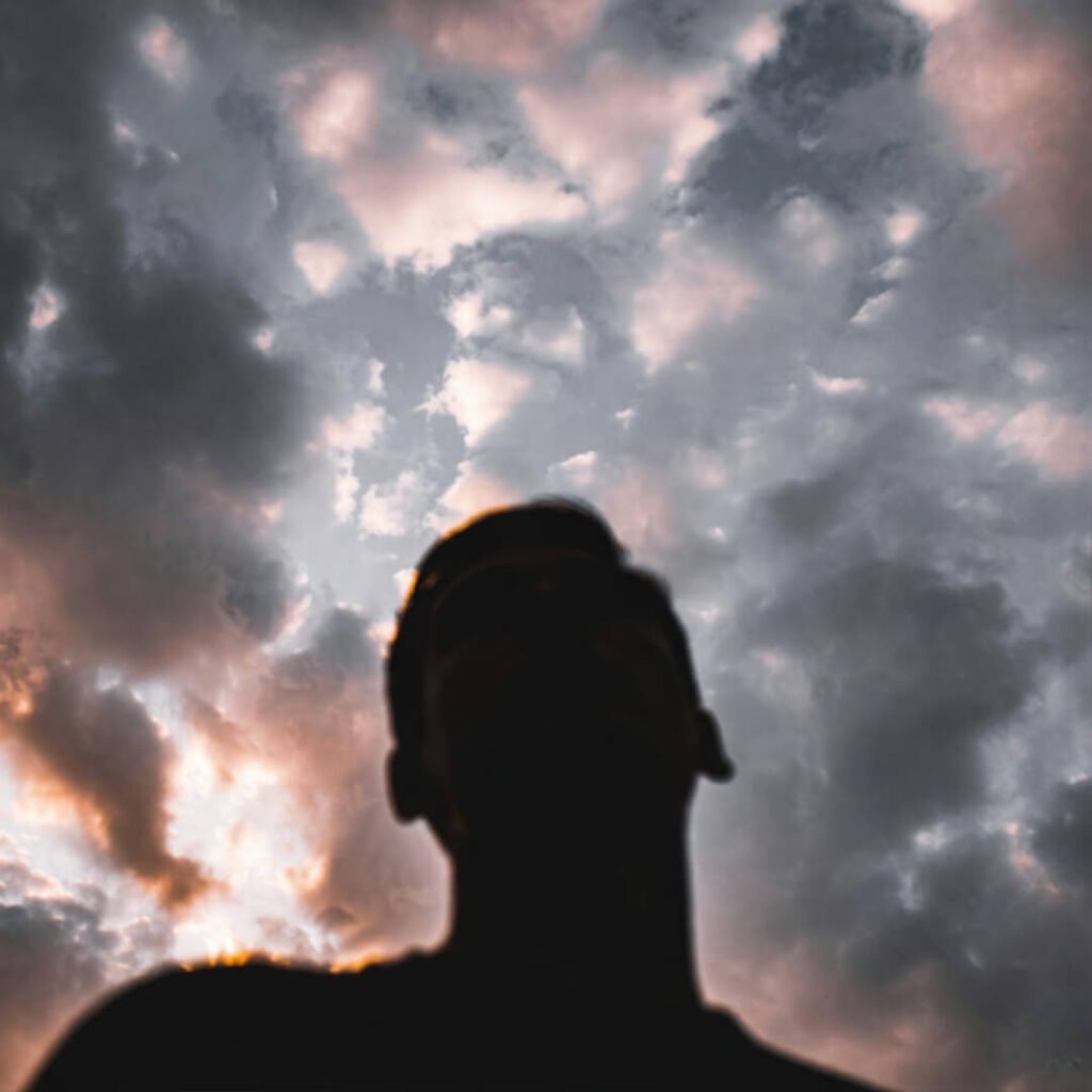 Defiant silhouette gazing at swirling storm clouds.