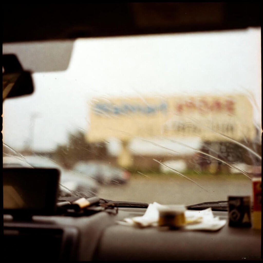 Rain-streaked car window overlooking blurred Target sign.