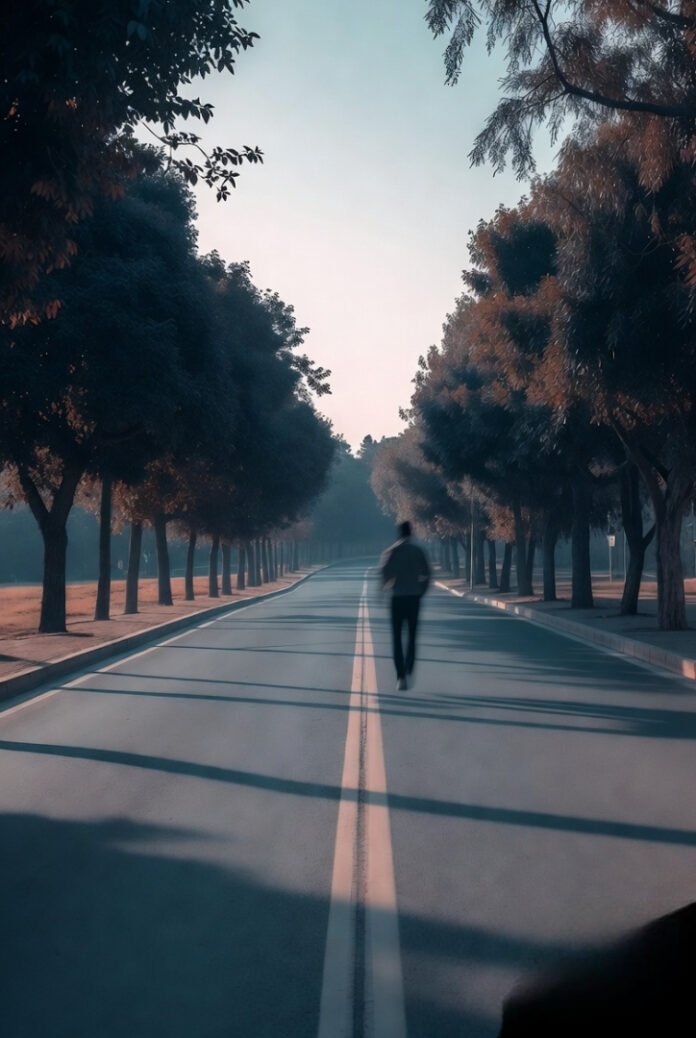 A person walking down a quiet street lined with trees, slightly blurred to show motion and calmness.